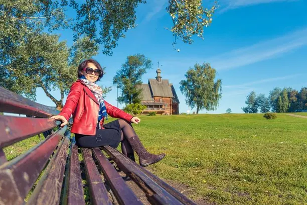 Khách ngồi ghế gỗ trong bảo tàng ngoài trời