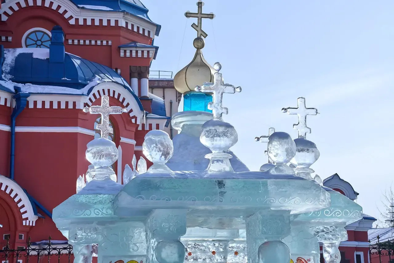 Nhà thờ Kazan màu đỏ mái xanh ở Irkutsk với các tượng băng trong sân mùa đông