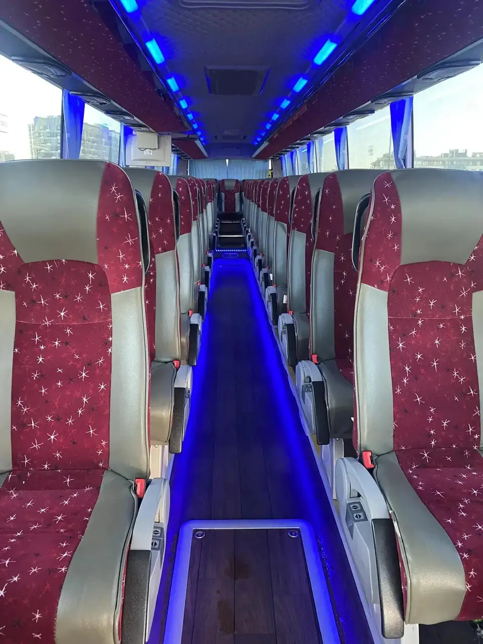 Lối đi giữa hai dãy ghế bọc vải đỏ, đèn LED xanh dọc trần và sàn, xe Zhong Tong